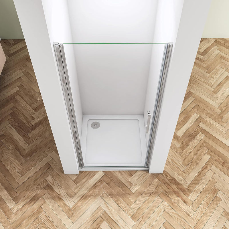 Angled view of frameless pivot shower door with polished chrome fittings